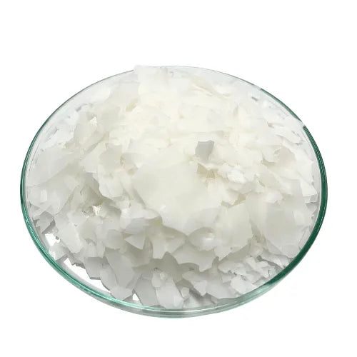 White flakes of Olivem 1000 emulsifier in a glass petri dish