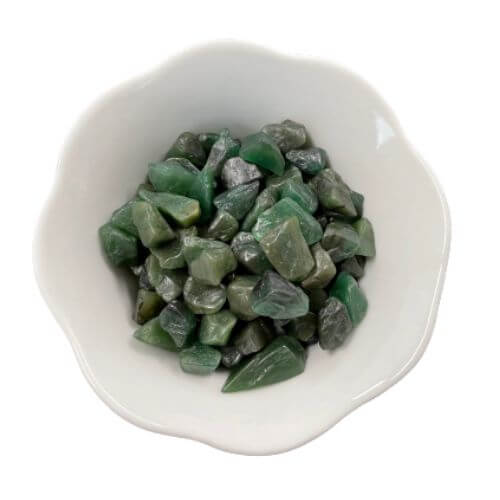 White bowl with green jade crystals in it