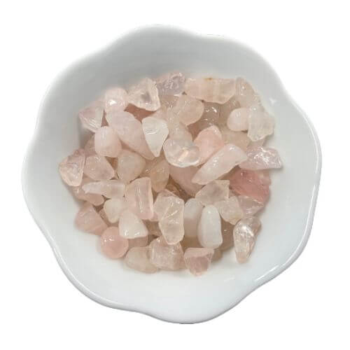 White bowl with pink rose quartz crystals in it