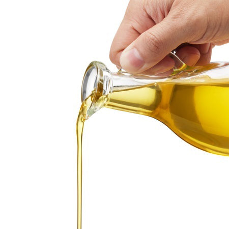 Macadamia Oil - Unrefined is light yellow coloured oil being poured from a bottle