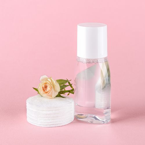 Micellar Water in clear bottle and flower to the side