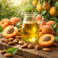 Apricot kernel oil in a jug on natural timber surrounded by apricots and apricot kernels