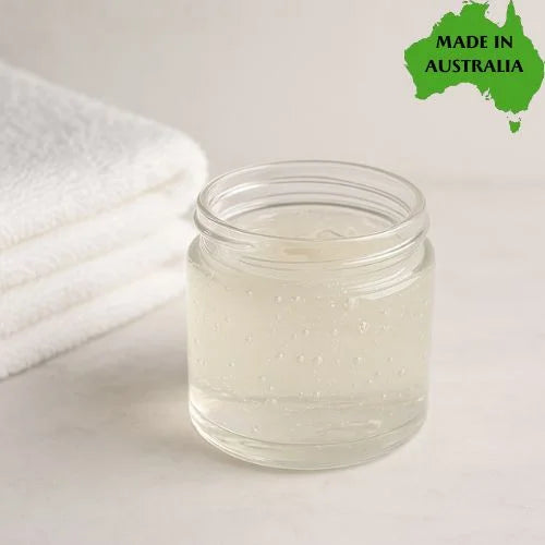 Clear glass jar of natural shower gel with a white towel on a light background, featuring 'Made in Australia' text.