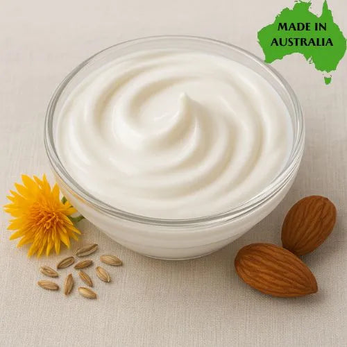 Bowl of paraben free cream base with almonds and a yellow flower on a beige background, with 'Made in Australia' label.