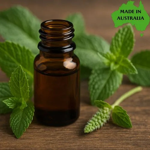 Brown glass bottle with peppermint piperita leaves on a wooden surface, labeled 'Made in Australia'.