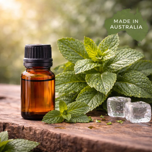 Brown glass bottle with black cap on a wooden surface with mint leaves and ice cubes, set against a blurred green background with 'Made in Australia' text.