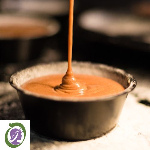 Caramel sauce being drizzled into a natural pottery pot